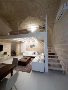 a living room with a white couch and a loft at Antica Cisterna di Lecce in Lecce
