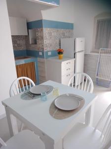 - une table et des chaises blanches dans la cuisine dans l'établissement Junno Maison Doli', à Mattinata