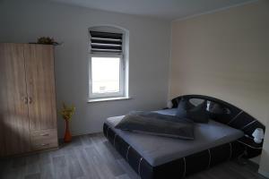 ein Schlafzimmer mit einem großen Bett und einem Fenster in der Unterkunft Fewo Schiffner in Bad Schandau