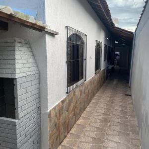 an alley with a gate on the side of a building at Casa de praia completa in Mongaguá