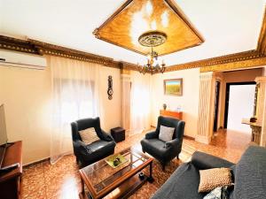 a living room with a couch and chairs and a chandelier at Casa Juan María in Alora