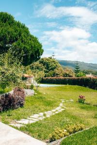 un jardín con un camino de piedra en el césped en Just Like Home Casa do Castanheiro, en Afife