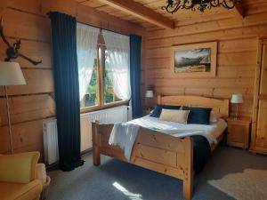 um quarto com uma cama num chalé de madeira em Willa Płazówka Białczańska em Białka Tatrzanska