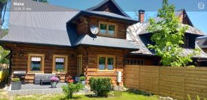 una casa di tronchi con tetto in metallo di Domeczek Góralski Zakopane a Zakopane