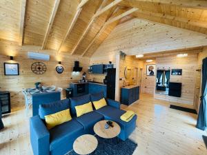 a living room with a blue couch and a kitchen at Holiday House Novus in Selno