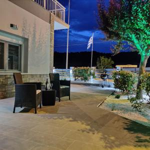 a patio with chairs and a table in front of a building at Mare Monte Luxury Apartments 4 in Kassandria