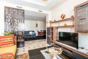 Appartement Rabat Agdal City Centre - SwiftStay في الرباط: غرفة معيشة مع تلفزيون بشاشة مسطحة كبيرة