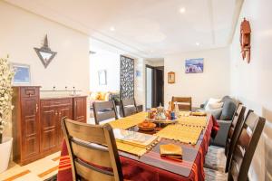 a dining room with a table and a kitchen at Appartement Rabat Agdal City Centre - SwiftStay in Rabat