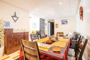 a dining room with a table and a kitchen at Appartement Rabat Agdal City Centre in Rabat