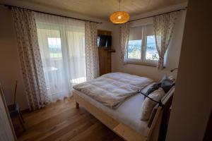 a bedroom with a bed and a window at Einfach Leben - Urlaub in den Bergen in Tauplitz