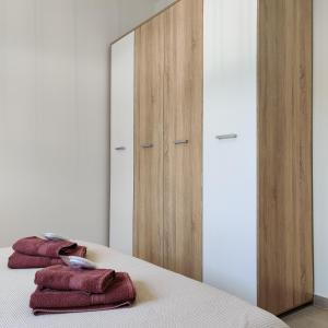 a bedroom with a mirror and three towels on a bed at Mare Monte Luxury Apartments 4 in Kassandria