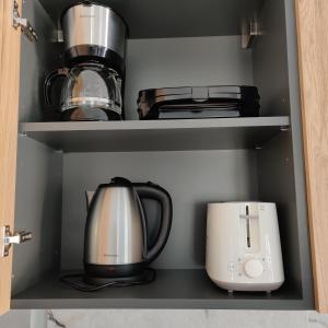 a coffee maker and a toaster in a cupboard at Mare Monte Luxury Apartments 4 in Kassandria