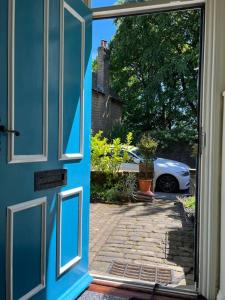 a door to a house with a car in a driveway at Rural Yorkshire Getaway - Modern Victorian Cottage, Long term stay offers, message direct in Luddenden Foot