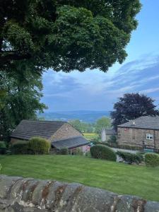 a yard with two houses and a field of grass at Rural Yorkshire Getaway - Modern Victorian Cottage, Long term stay offers, message direct in Luddenden Foot