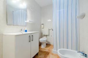 a bathroom with a toilet and a sink and a mirror at Apartamentos Mayans in Sant Ferran de Ses Roques +42 photos