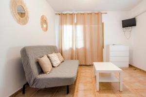 ein Wohnzimmer mit einem Sofa und einem Tisch in der Unterkunft Apartamentos Mayans in Sant Ferran de Ses Roques