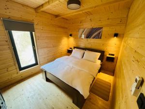 a bedroom with a bed in a wooden cabin at Holiday House Adamo in Selno +9 photos