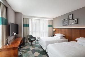 a hotel room with two beds and a desk at Four Points by Sheraton Istanbul Kagithane in Istanbul