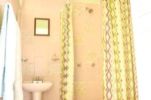 baño con lavabo y cortina de ducha en CANCUN GUEST HOUSE, en Cancún