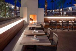 un restaurante con mesas y sillas de madera y chimenea en Hotel Adeline, Scottsdale, a Tribute Portfolio Hotel, en Scottsdale