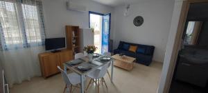 a living room with a table and chairs and a couch at Dionysia apartments in Livadia