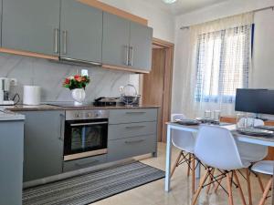 a kitchen with a table and a table and chairs at Dionysia apartments in Livadia
