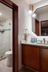 a bathroom with a toilet and a sink and a mirror at Hotel Adeline, Scottsdale, a Tribute Portfolio Hotel in Scottsdale