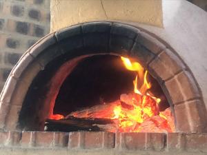 a brick oven with a fire in it at Comfortable 10 guest villa in a Big 5 Game Reserve in Dinokeng Game Reserve