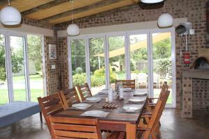 a dining room with a wooden table and chairs at Comfortable 10 guest villa in a Big 5 Game Reserve in Dinokeng Game Reserve