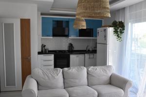 a white couch in a kitchen with a white refrigerator at Serenity Apart in Antalya