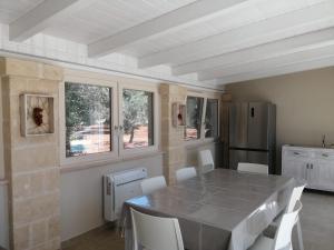 kuchnia ze stołem, krzesłami i lodówką w obiekcie Terra Mater - Exclusive Cottage - w mieście Ostuni