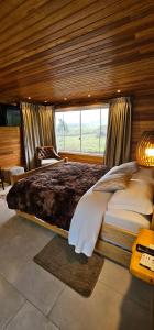 En eller flere senge i et værelse på Chalé do Lago Urupema SC