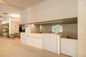 an office lobby with a reception counter and chairs at Holiday Inn Thessaloniki, an IHG Hotel in Thessaloniki
