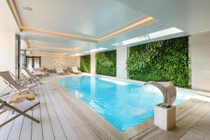 a swimming pool in a hotel with a green wall at Holiday Inn Thessaloniki, an IHG Hotel in Thessaloniki