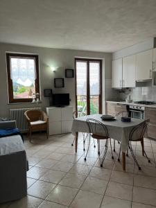 eine Küche und ein Wohnzimmer mit einem Tisch und Stühlen in der Unterkunft Appartamento MANUELA in Consiglio di Rumo
