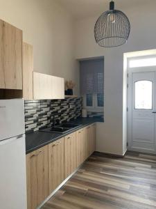 a kitchen with wooden cabinets and a black counter top at Alani house in Tinos