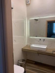 uma casa de banho com um lavatório e um espelho em Alani house em Tinos