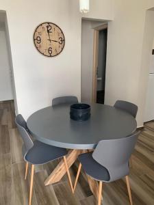 una mesa con sillas y un reloj en la pared en Alani house, en Tinos