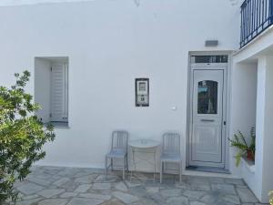 two chairs and a table on a patio at Alani house in Tinos