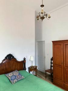 a bedroom with a green bed and a chandelier at Pias Guesthouse in Pias