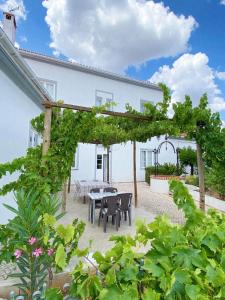 um pátio com uma pérgola de madeira, uma mesa e cadeiras em Pias Guesthouse em Pias