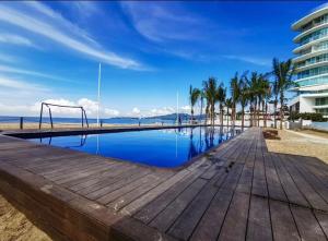 un paseo marítimo con parque infantil y palmeras en una playa en Studio con vista al mar en Aria Ocean Nvo Vallarta, en Nuevo Vallarta 