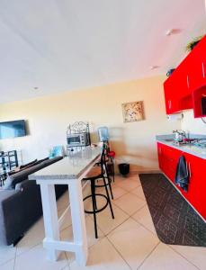 cocina con encimera blanca y armarios rojos en Studio con vista al mar en Aria Ocean Nvo Vallarta, en Nuevo Vallarta 