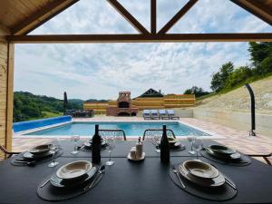 a table with glasses and napkins on a table in front of a pool at Holiday House Adamo in Selno