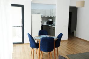 a dining room with a table and blue chairs at White Flat in Bucharest