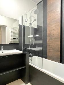 y baño con ducha, lavabo y bañera. en I&M Apartments Sikorskiego Wrocław, en Wroclaw