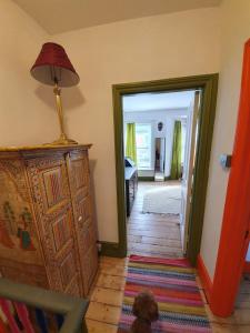a room with a dresser and a lamp and a hallway at Casa Colour Margate in Margate