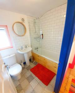 a bathroom with a toilet and a tub and a sink at Casa Colour Margate in Margate