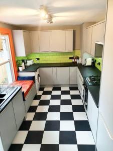 a kitchen with a black and white checkered floor at Casa Colour Margate in Margate