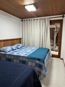 穆庫熱的住宿－Villa Andorinha, Apt 03，一间卧室设有两张床和窗户。